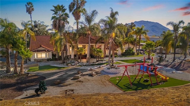 surrounding community with a mountain view and a playground