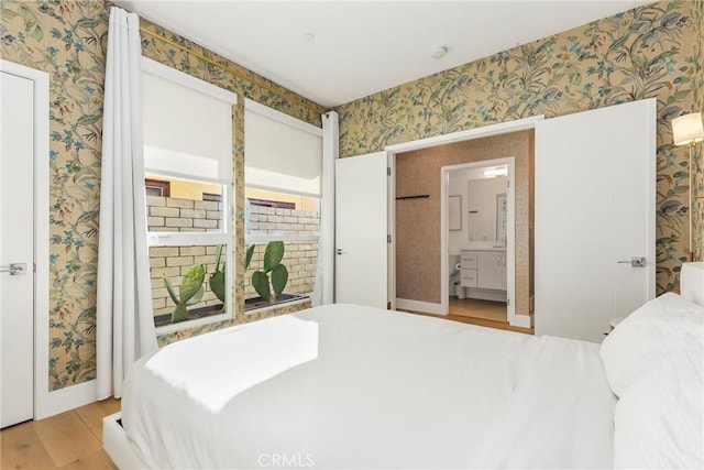 bedroom featuring ensuite bath and light hardwood / wood-style flooring