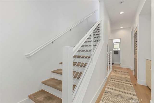 staircase with hardwood / wood-style floors