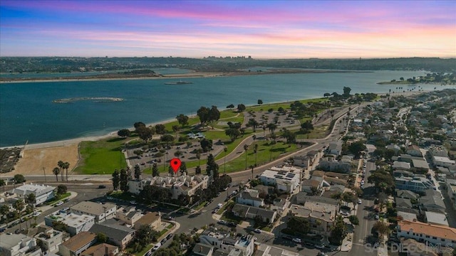 aerial view at dusk featuring a water view