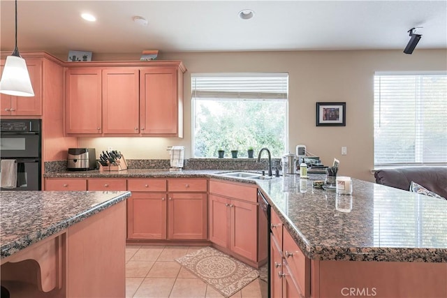 kitchen with light tile patterned flooring, pendant lighting, double oven, sink, and stainless steel dishwasher