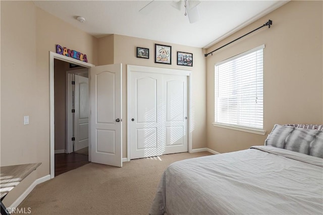 carpeted bedroom featuring ceiling fan and a closet