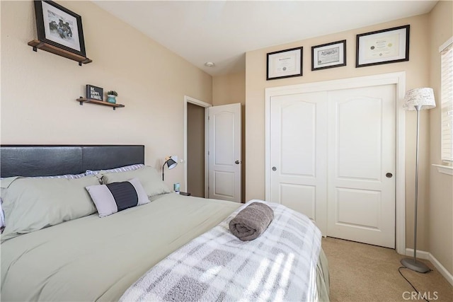 bedroom featuring light colored carpet and a closet