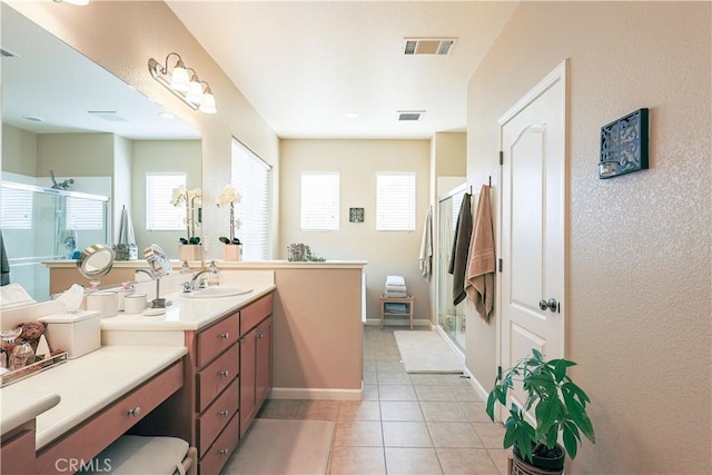 bathroom with vanity, plenty of natural light, tile patterned floors, and walk in shower