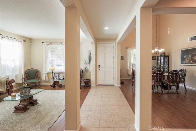 foyer with a chandelier and light tile patterned floors