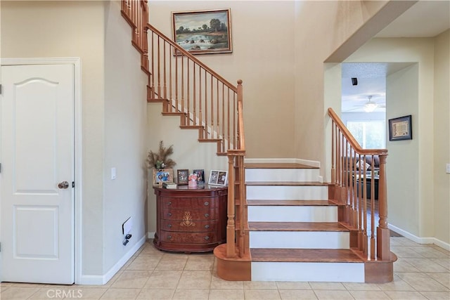 staircase featuring tile patterned flooring and ceiling fan