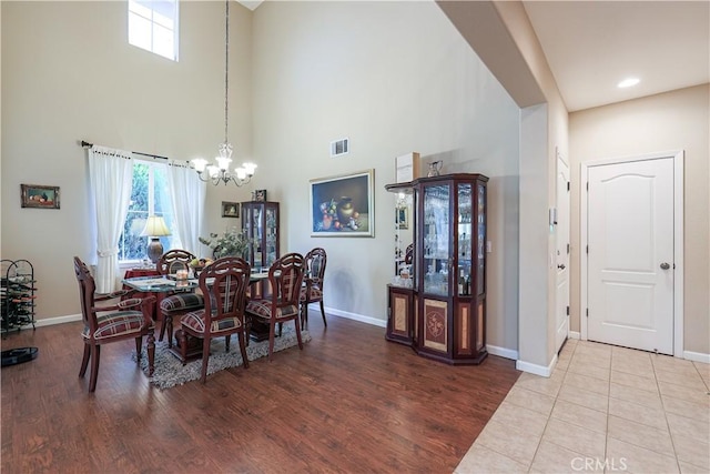 dining area featuring a high ceiling, plenty of natural light, and an inviting chandelier