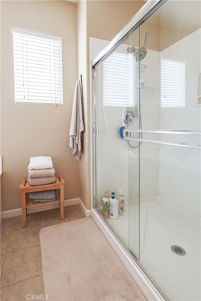 bathroom with tile patterned flooring and a shower with door