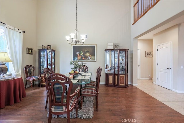 dining space featuring a chandelier, hardwood / wood-style floors, and a high ceiling