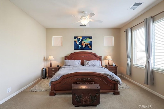 bedroom featuring multiple windows, light carpet, and ceiling fan