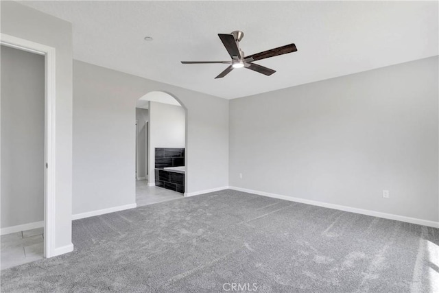 carpeted spare room featuring ceiling fan