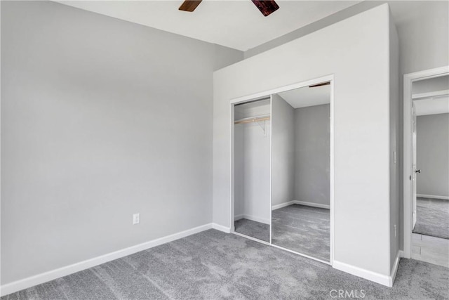 unfurnished bedroom featuring carpet flooring, ceiling fan, and a closet