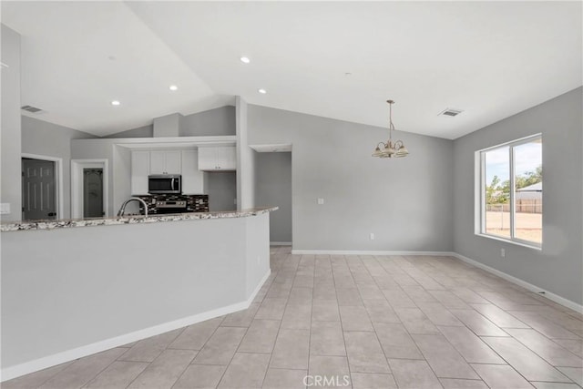 kitchen with light stone countertops, an inviting chandelier, pendant lighting, lofted ceiling, and white cabinets