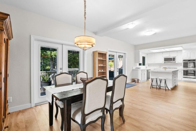 dining room with light hardwood / wood-style floors, sink, and french doors