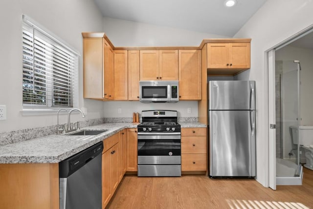 kitchen with light hardwood / wood-style floors, sink, appliances with stainless steel finishes, and vaulted ceiling