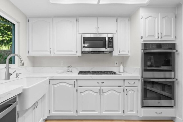 kitchen with white cabinets, sink, and appliances with stainless steel finishes