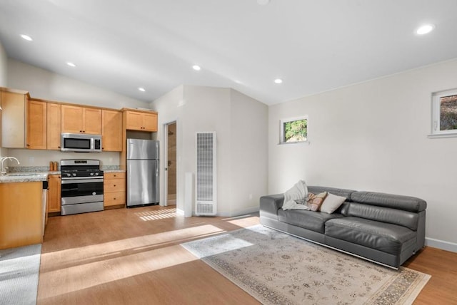 living room with light hardwood / wood-style floors, lofted ceiling, and sink