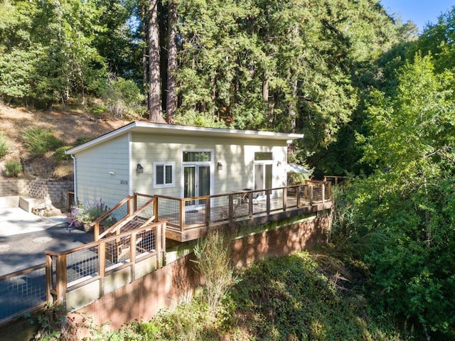 rear view of property with a deck and french doors