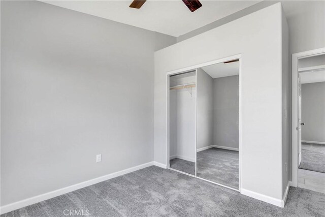 unfurnished bedroom featuring carpet, ceiling fan, and a closet