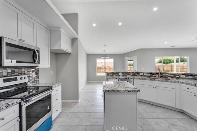 kitchen featuring a wealth of natural light, sink, white cabinets, and appliances with stainless steel finishes