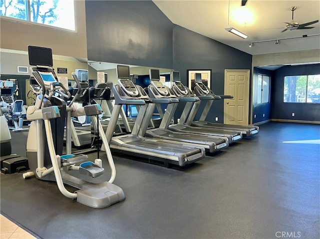 workout area featuring a towering ceiling, ceiling fan, and a healthy amount of sunlight