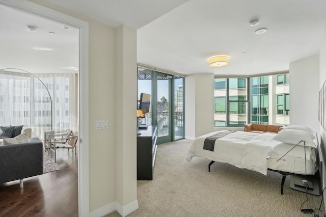 bedroom with access to outside, floor to ceiling windows, and carpet