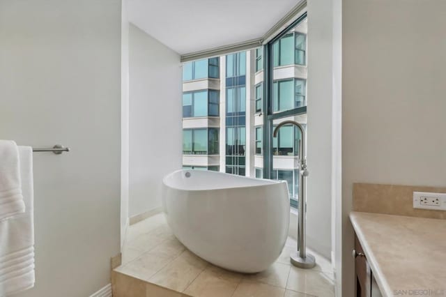 bathroom featuring tile patterned flooring, a tub, and floor to ceiling windows