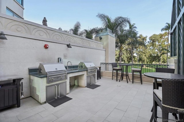 view of patio / terrace featuring an outdoor kitchen, a grill, and sink