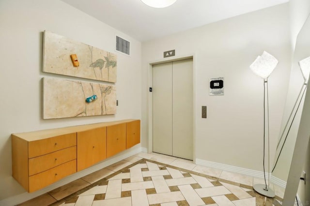 hall featuring light tile patterned floors and elevator