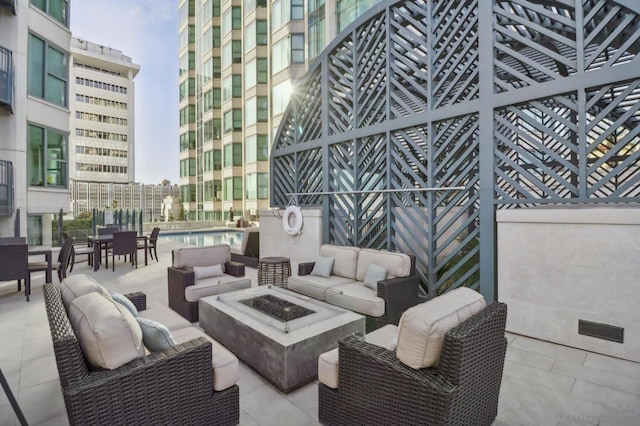 view of patio with an outdoor living space with a fire pit