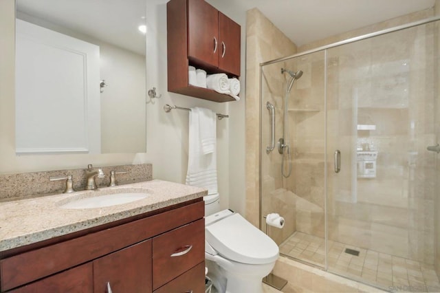 bathroom with vanity, a shower with shower door, and toilet