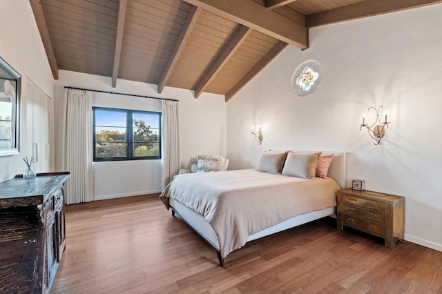 bedroom with hardwood / wood-style floors, vaulted ceiling with beams, and wooden ceiling