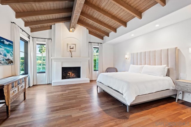 bedroom with a fireplace, beamed ceiling, high vaulted ceiling, and hardwood / wood-style flooring