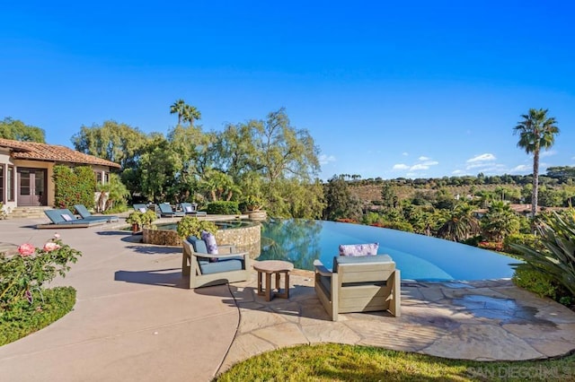 view of swimming pool with an in ground hot tub and a patio