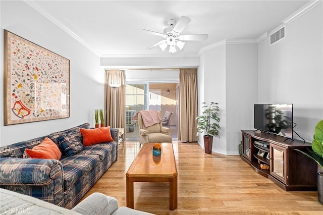 living room featuring ceiling fan, light wood-type flooring, and crown molding