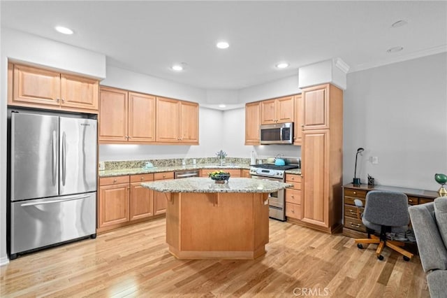 kitchen with a kitchen breakfast bar, stainless steel appliances, light brown cabinets, light hardwood / wood-style floors, and a kitchen island