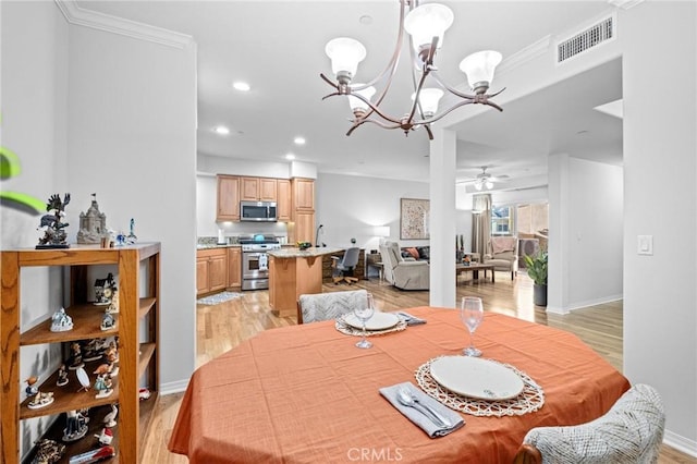 dining room with light hardwood / wood-style floors, ceiling fan with notable chandelier, and ornamental molding