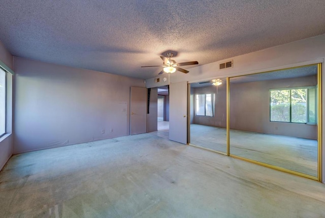 unfurnished bedroom with ceiling fan, a textured ceiling, a closet, and carpet floors