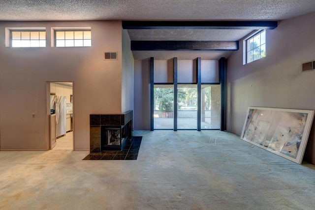 living room with beam ceiling, light colored carpet, and a high ceiling