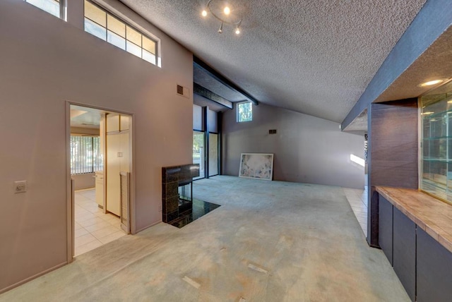 carpeted living room with plenty of natural light, a high ceiling, and a textured ceiling