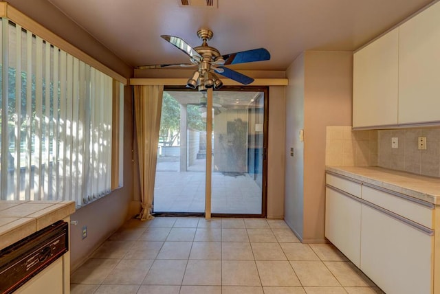 doorway with ceiling fan and light tile patterned flooring