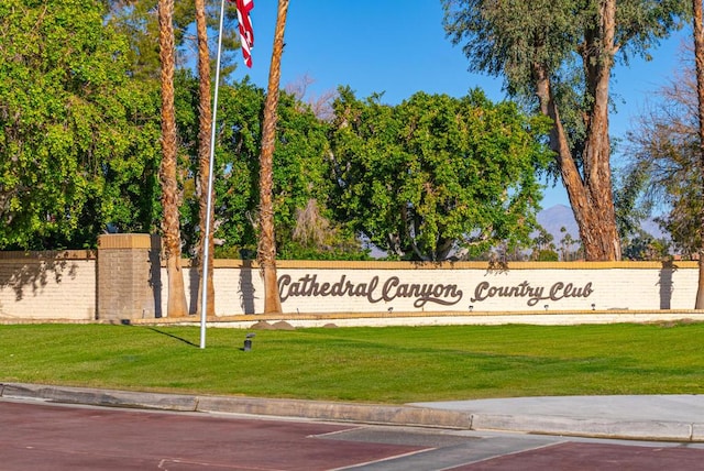 community sign featuring a yard