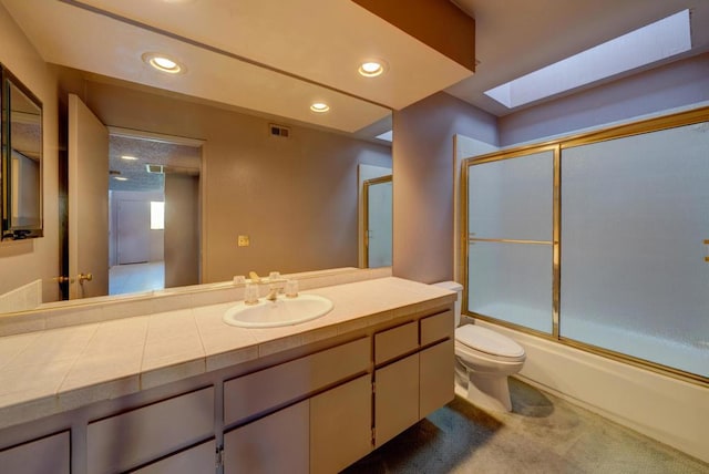 full bathroom featuring enclosed tub / shower combo, vanity, a skylight, and toilet