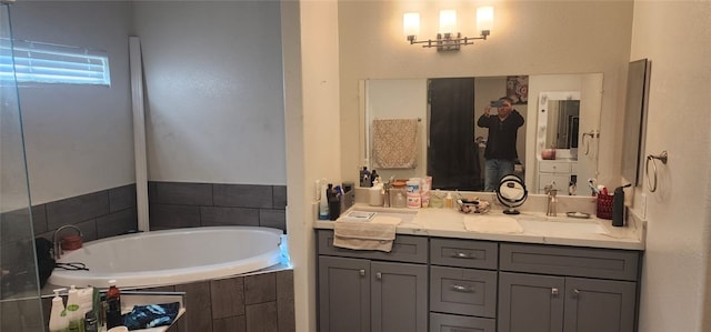 bathroom featuring vanity and a relaxing tiled tub