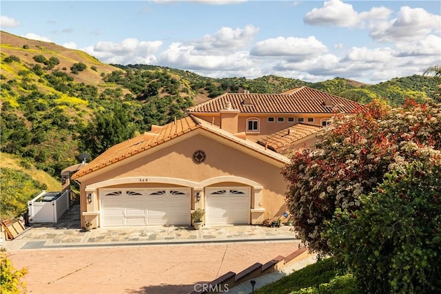 mediterranean / spanish house featuring a mountain view and a garage