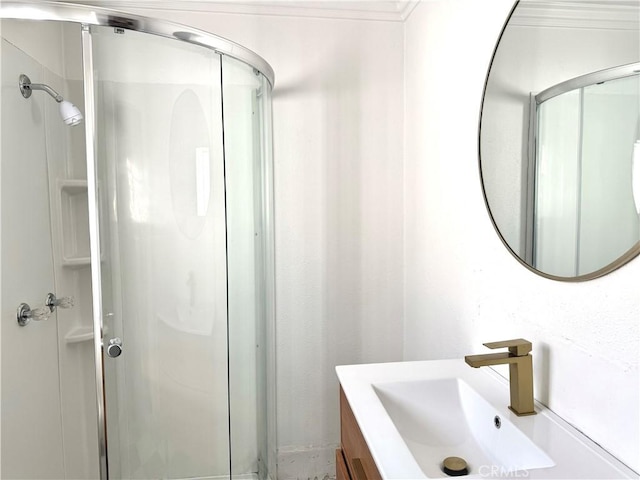 bathroom featuring walk in shower, ornamental molding, and sink