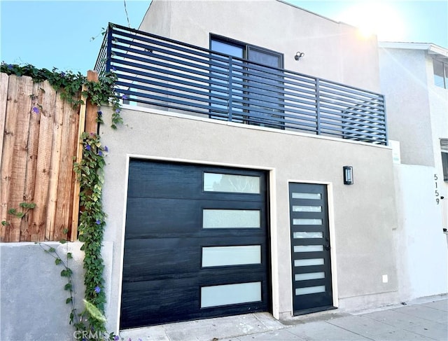 view of exterior entry with a balcony and a garage