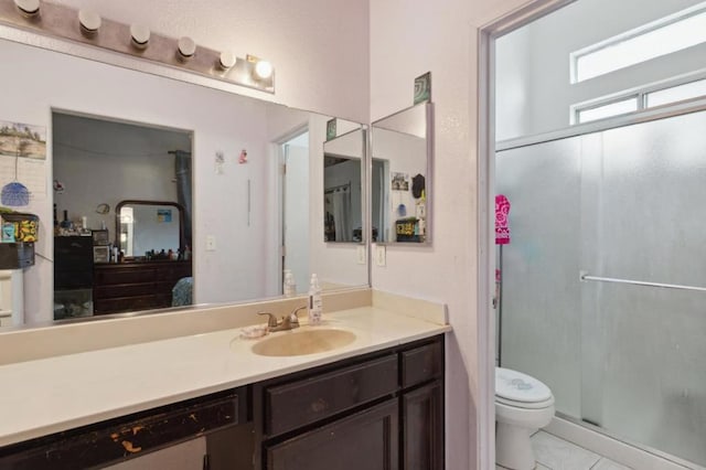 bathroom with vanity, tile patterned flooring, a shower with door, and toilet