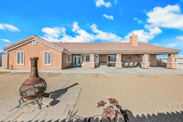 back of house with a patio area and an outdoor fire pit