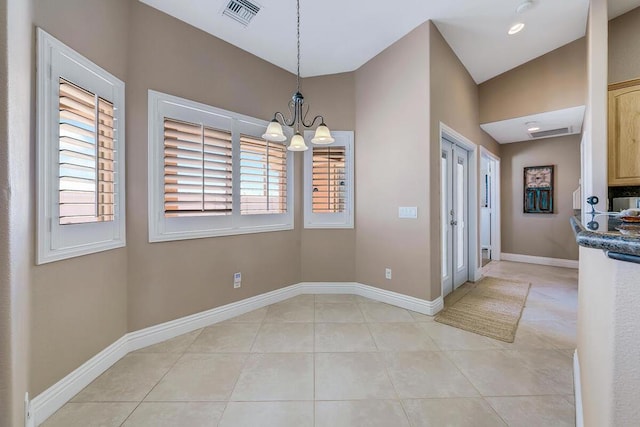 unfurnished dining area featuring an inviting chandelier and light tile patterned floors